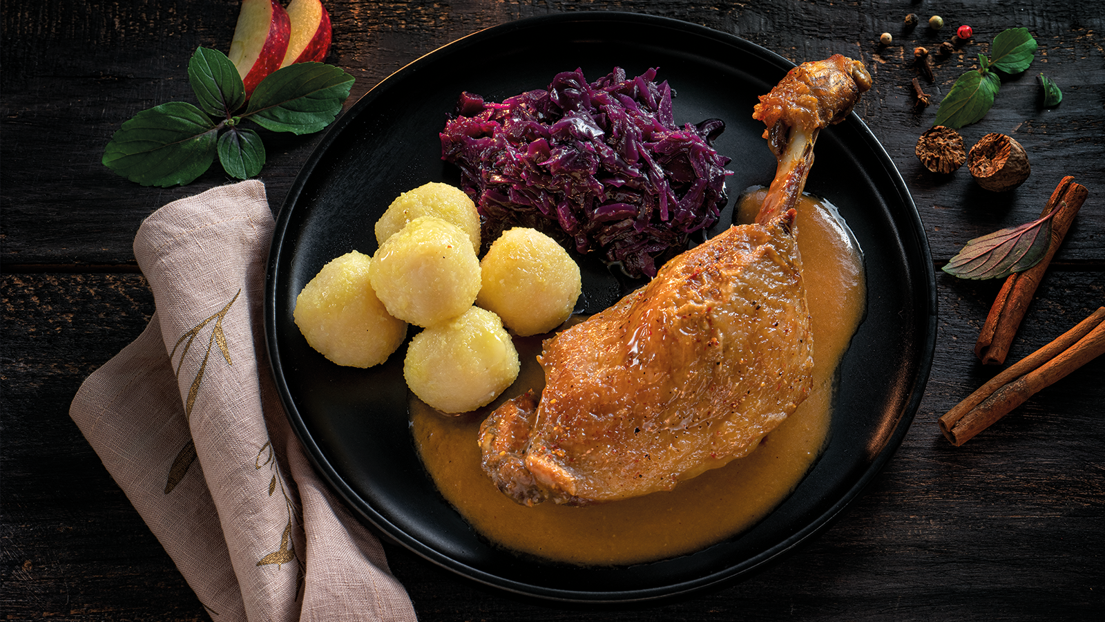Entenkeule mit Kartoffeln und Rotkohl auf einem Teller angerichtet