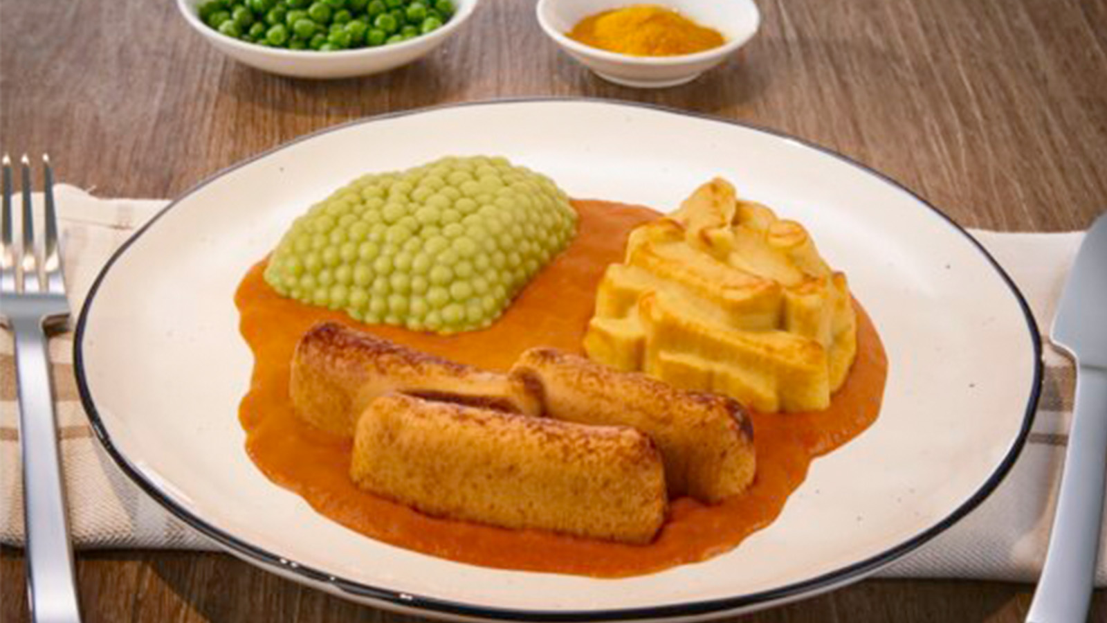 Pürierte Bratwurst in Currysoße mit Pommes aus Kartoffelzubereitung dazu Erbsen von WinVitalis