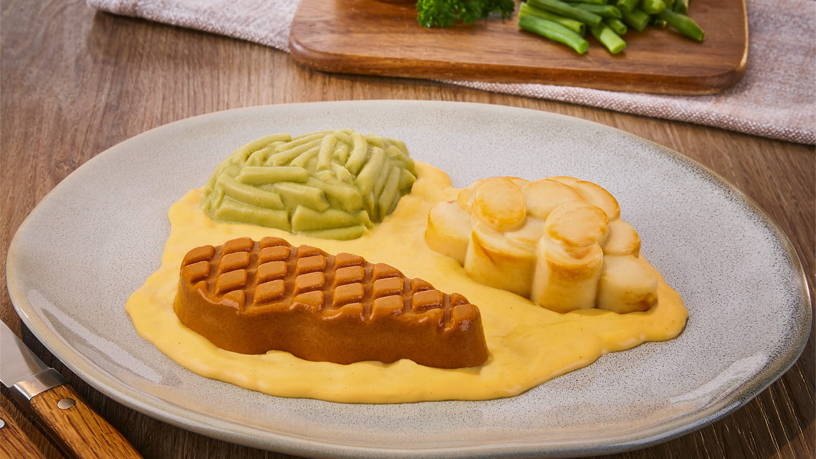 Püriertes Rinderhacksteak in Kräuterbuttersoße, dazu Bohnen und Bratkartoffeln