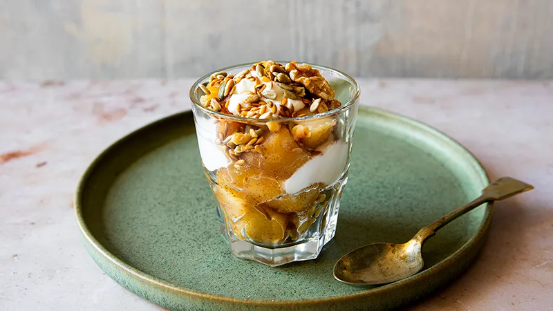 Obstdessert im Glas, garniert mit verschiedenen Nüssen