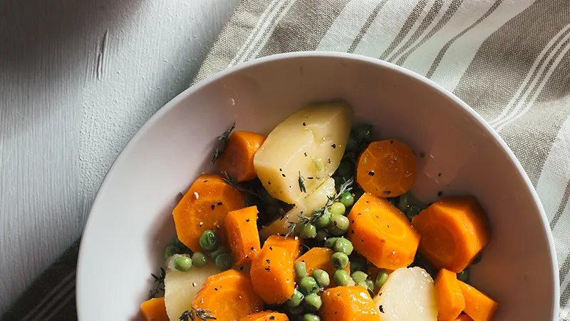 Gekochte Kartoffeln, Möhren und Erbsen in einer Schüssel