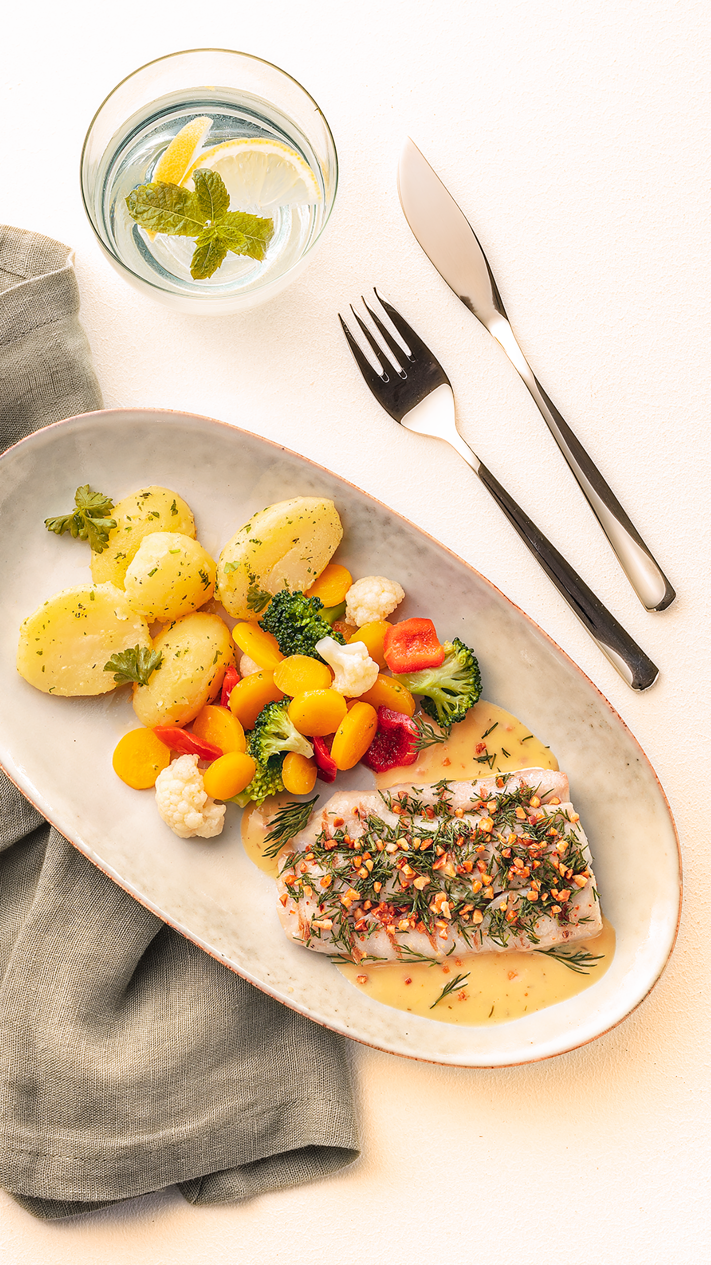 Länglicher Teller mit einem Fischfilet, Salzkartoffeln und gemischtem Gemüse