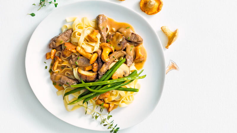 Pilzragout auf Tagliatelle, angerichtet auf einem Teller