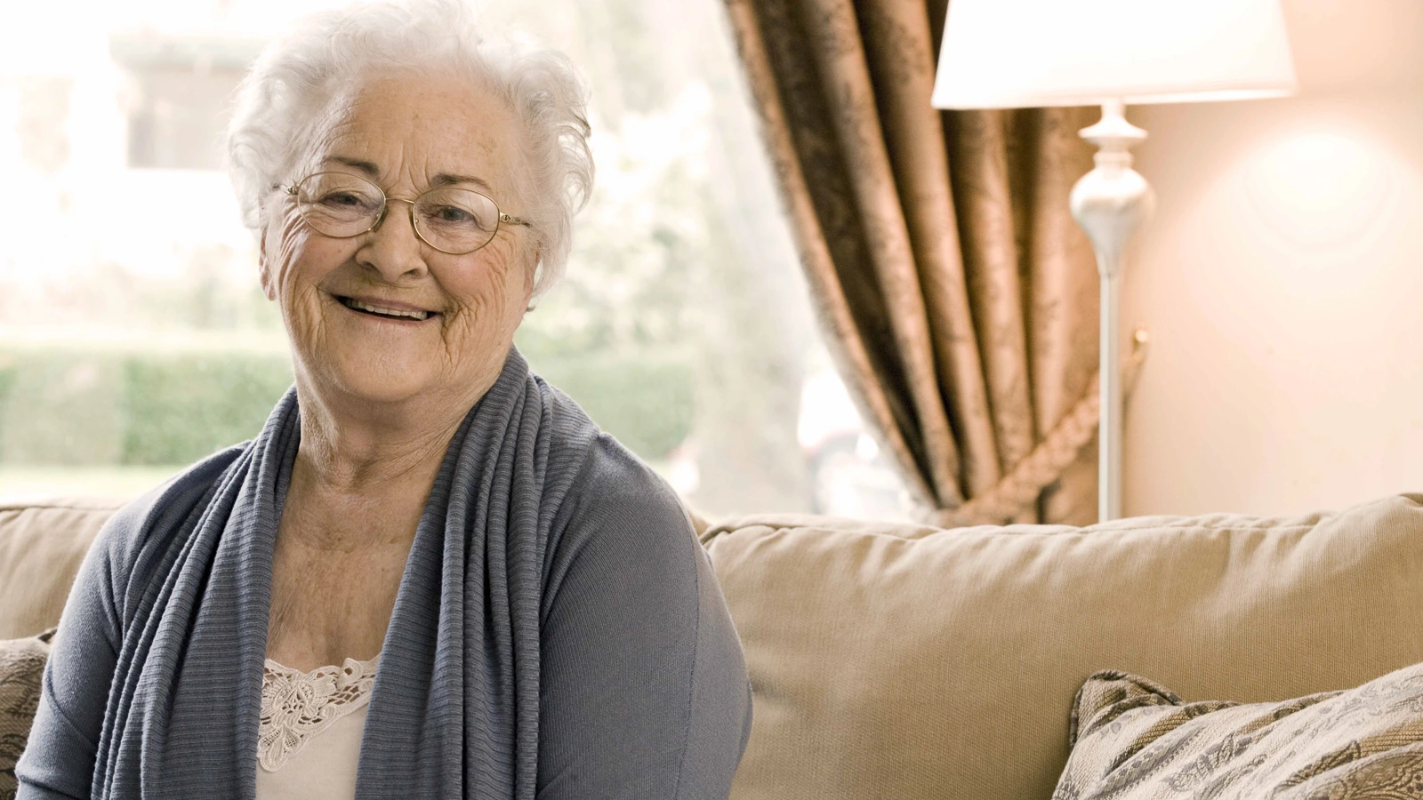Seniorin sitzt in ihrem Wohnzimmer