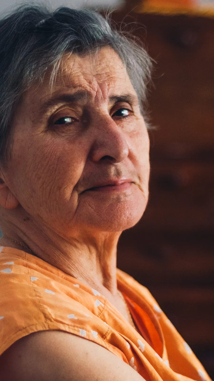 Ältere Frau blickt sorgenvoll zum Betrachter