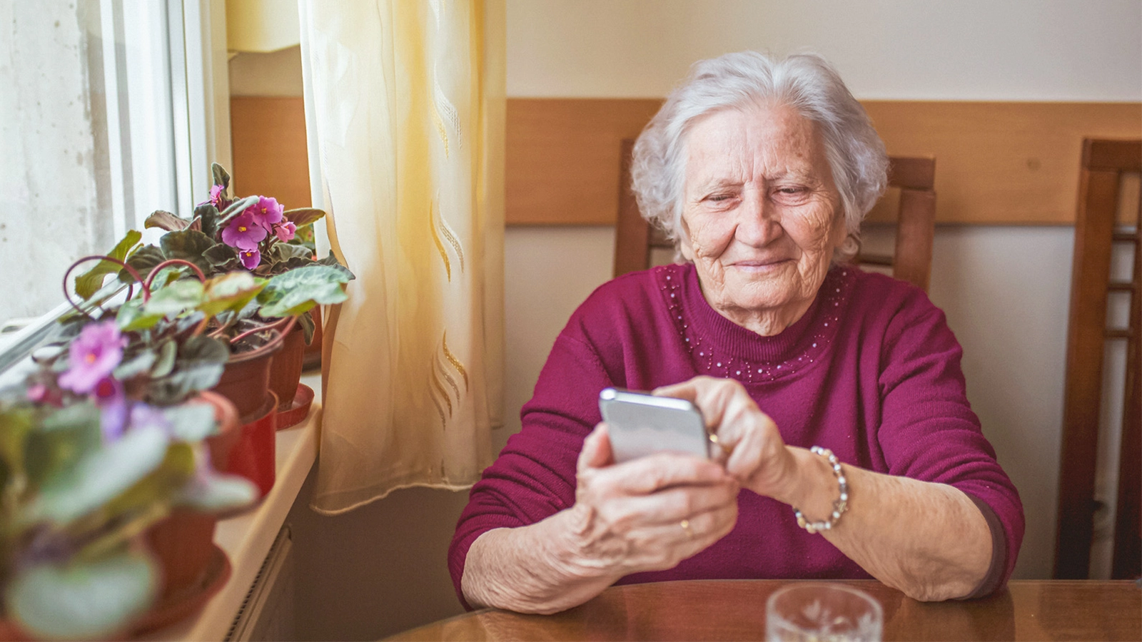 Frau sitzend  mit Smartphone in der Hand
