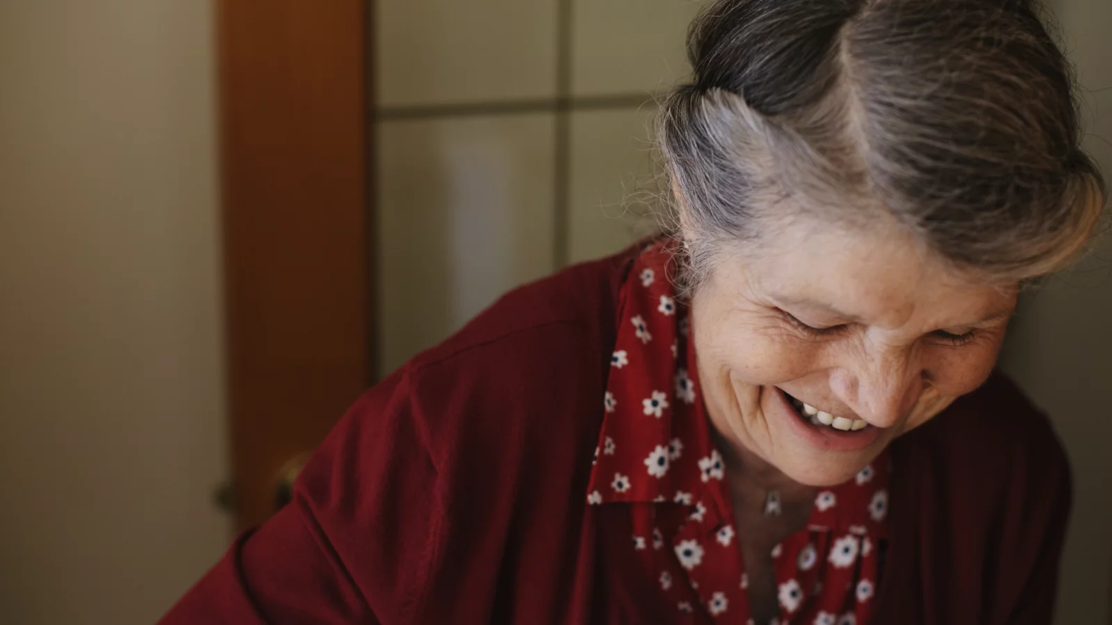 Seniorin lächelt bei ihrer Tätigkeit