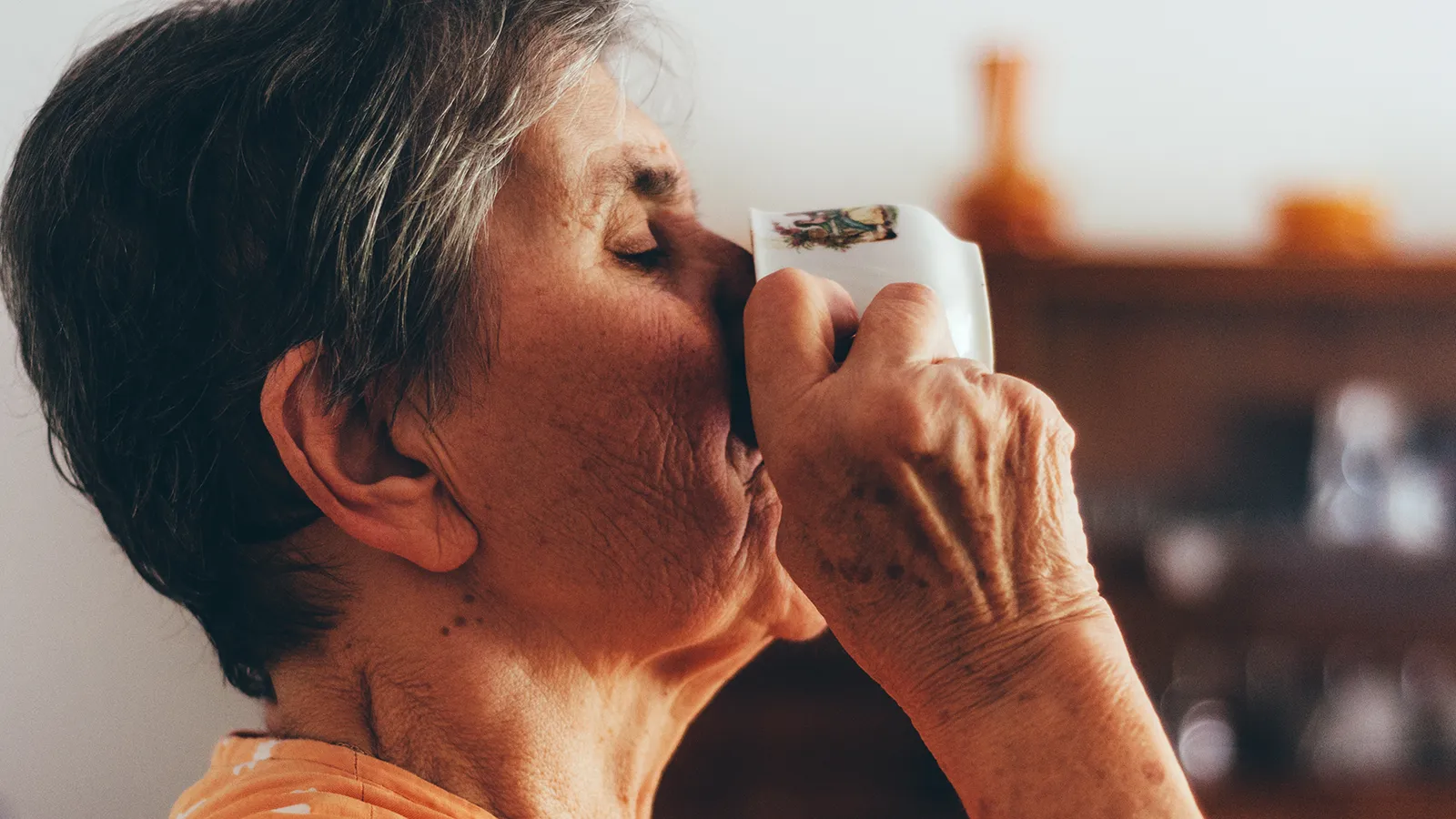 Frau trinkt genüsslich aus einer Tasse Kaffee