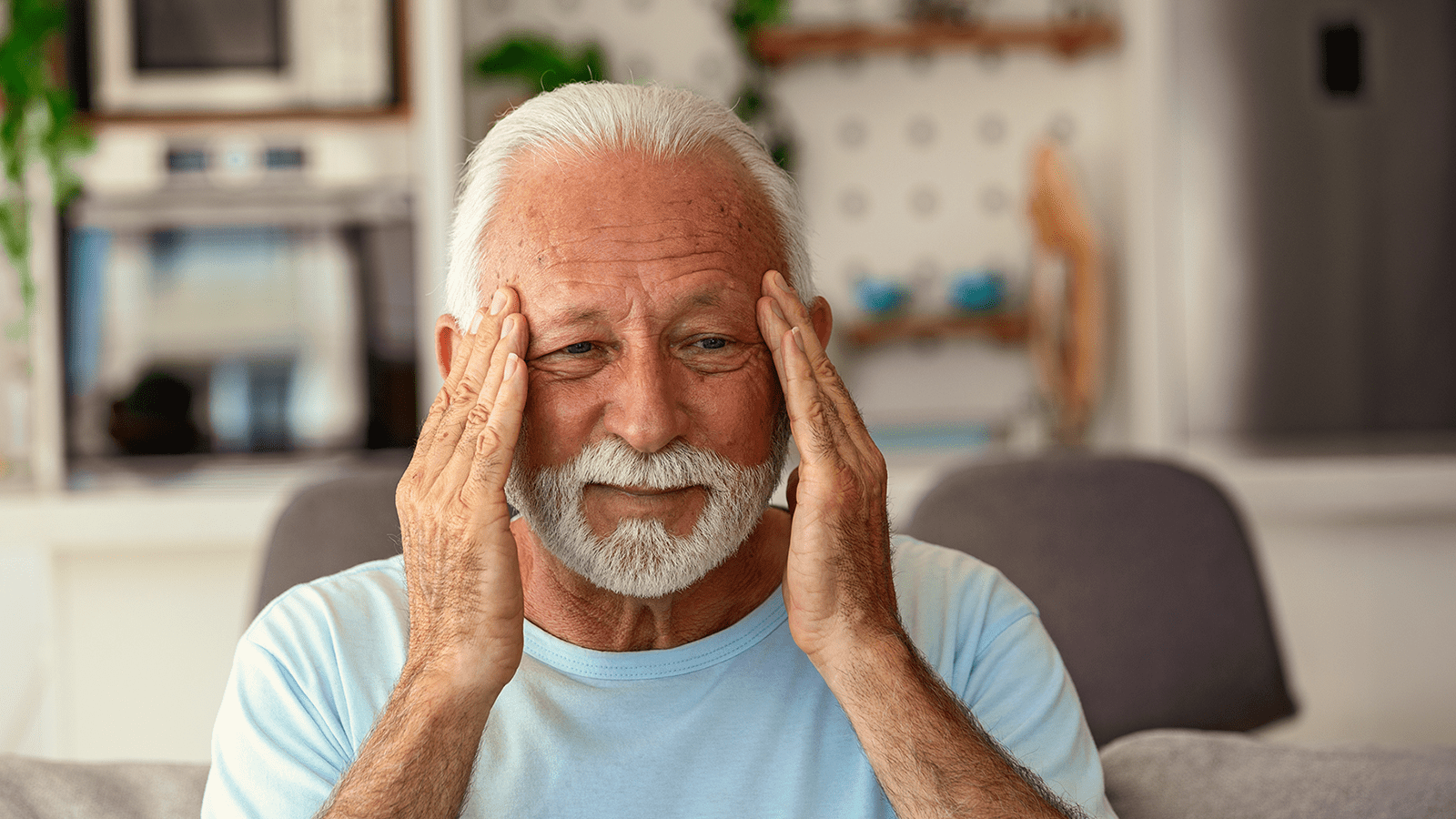 Mann hält beide Hände am Kopf