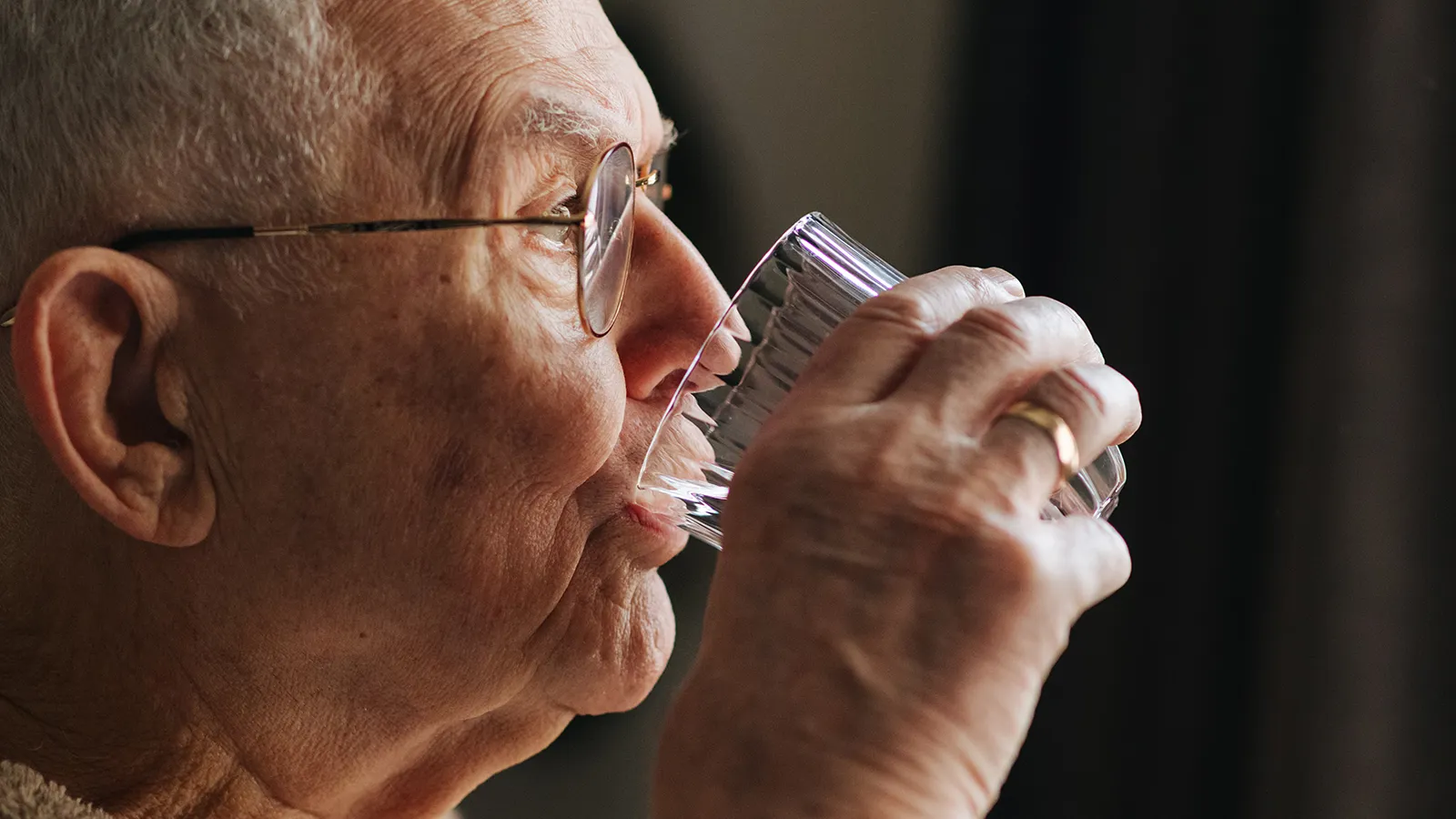 Mann trinkt aus Wasserglas