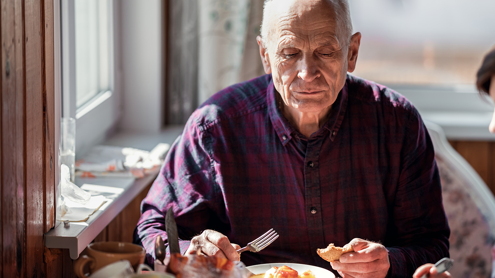 Älterer Mann sitzt appetitlos beim Essen