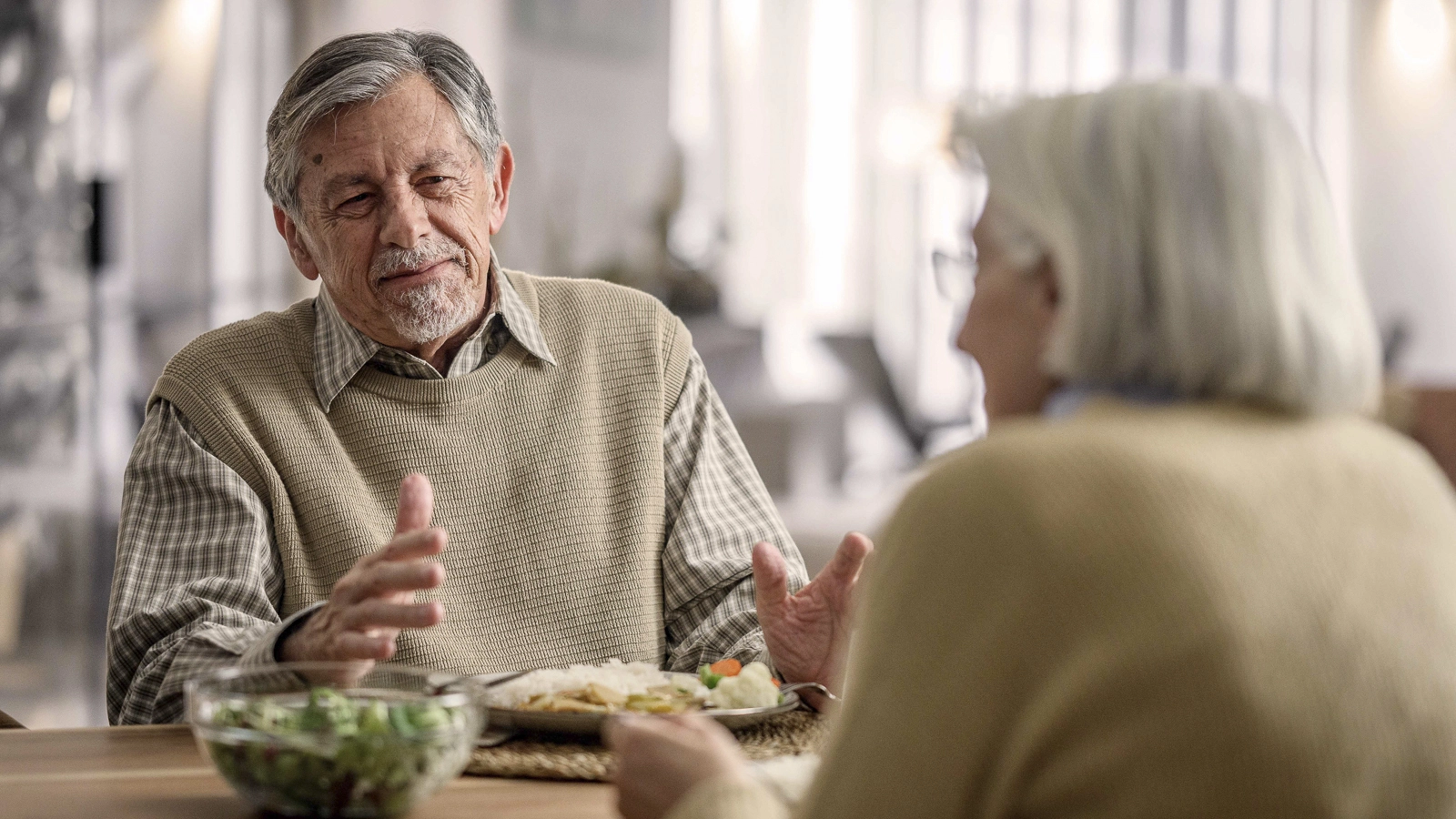 Junger Mann hilft älterem Mann beim Aufstehen aus dem Bett