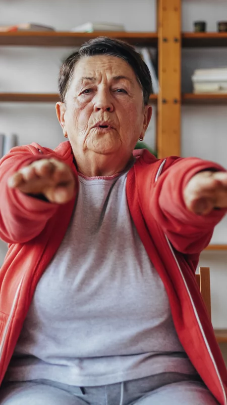 Frau macht Gymnastik auf einem Stuhl