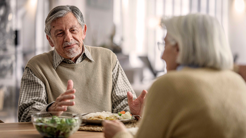 Junger Mann hilft älterem Mann beim Aufstehen aus dem Bett